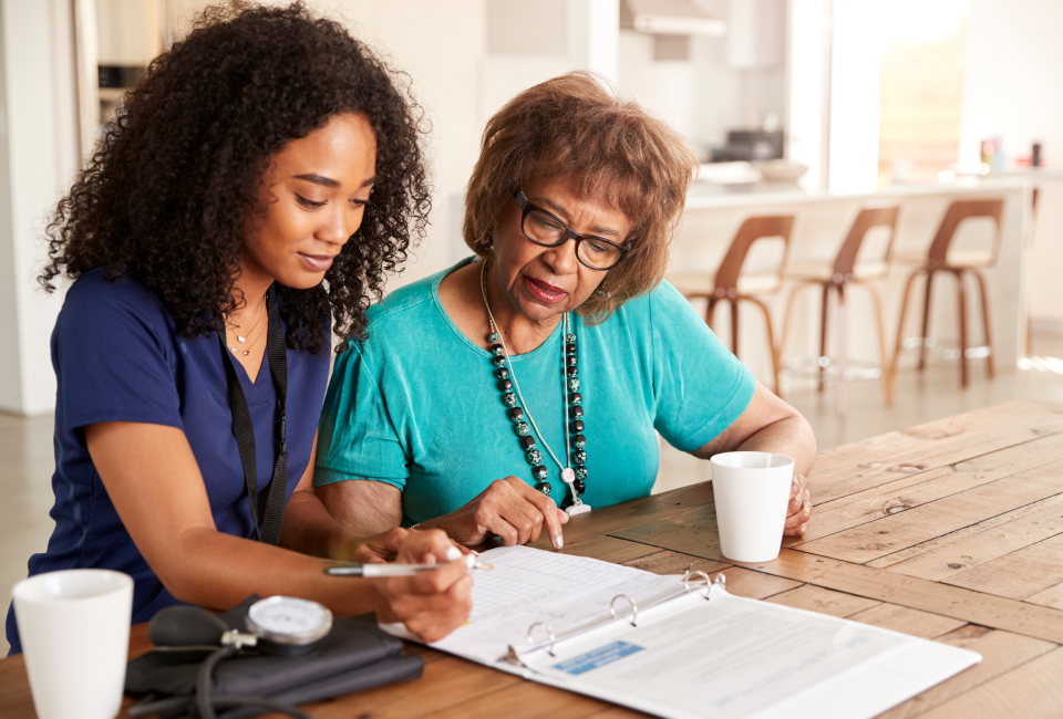 two women looking a paper at table