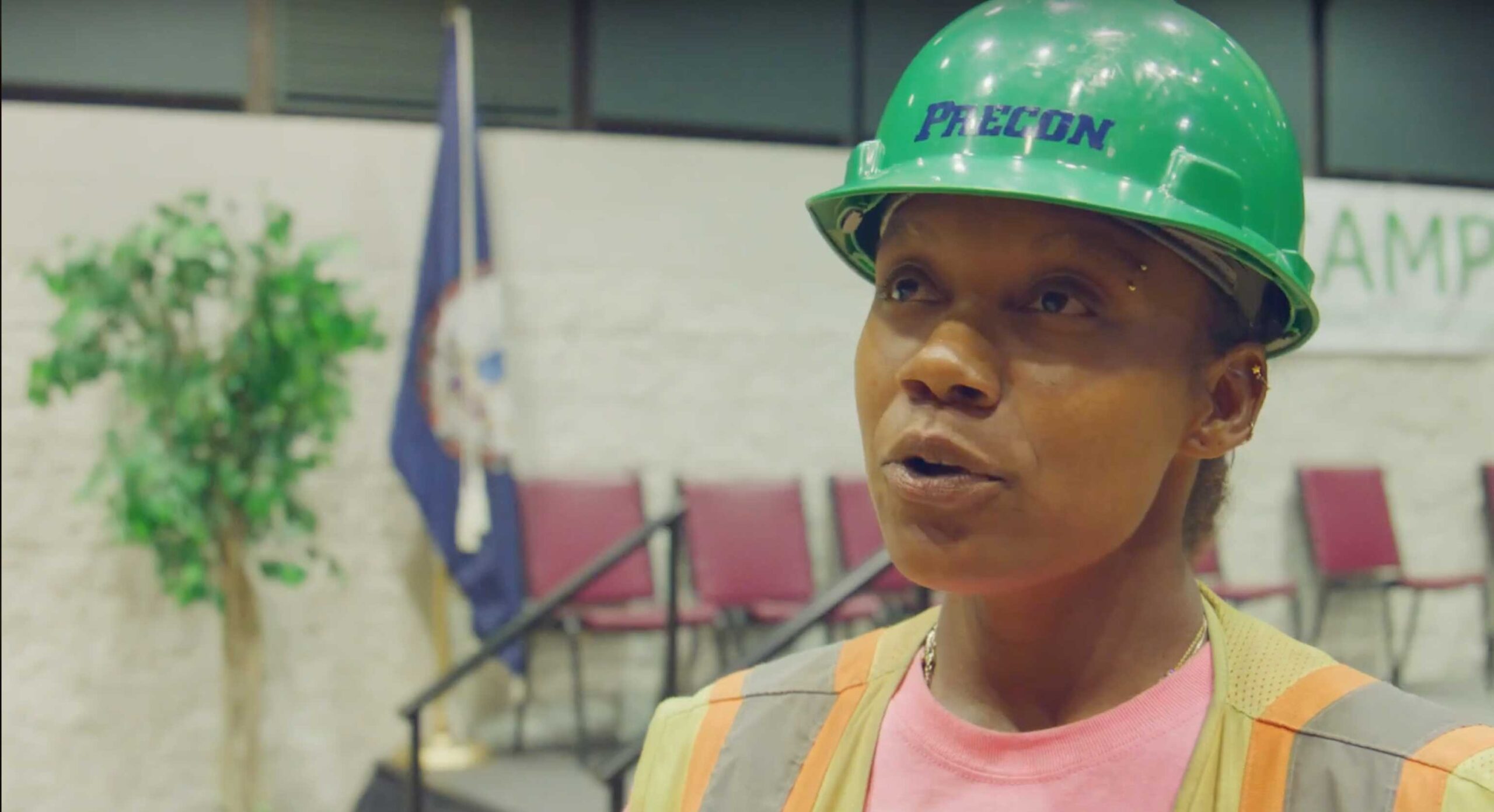 woman wearing green hard hat and work vest